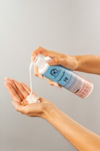 Main appliquant le masque Organiqplex avec un flacon pompe, gel blanc déposé dans la paume de la main