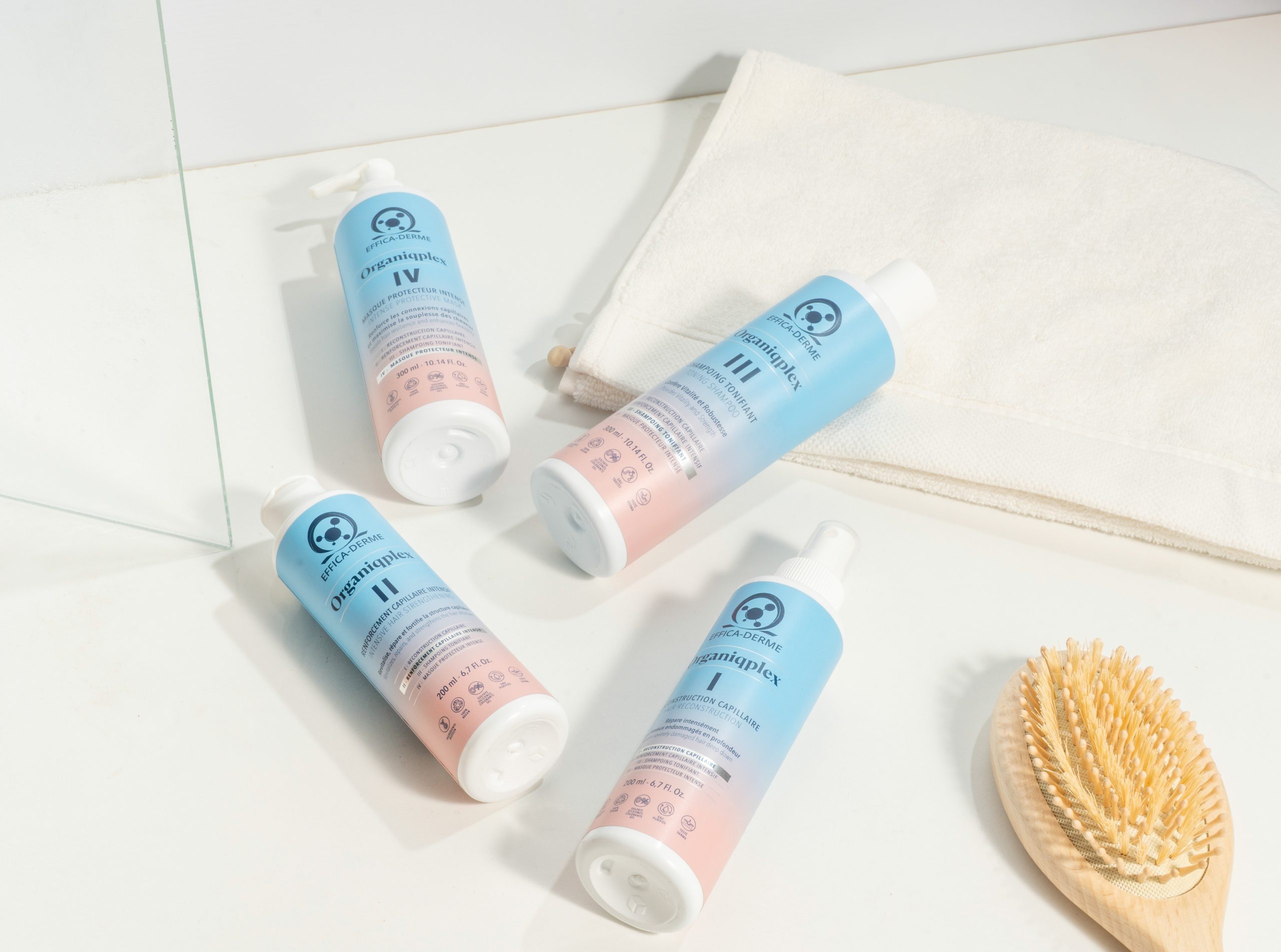 Les quatre produits Organiqplex debout avec une brosse, présentation du protocole de reconstruction capillaire